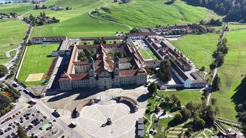 Elevated view of Einsiedeln Abbey, its forecourt and surrounding green fields Stockbeeldmateriaal 347762314
