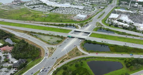 Elevated view of freeway diverging diamond interchange junction with fast moving Stock Footage 283884210