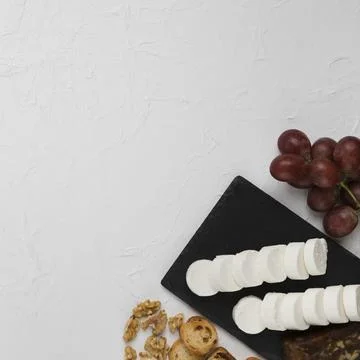 Elevated view goat cheese slice slate rock with grapes bread walnut textured 스톡 사진