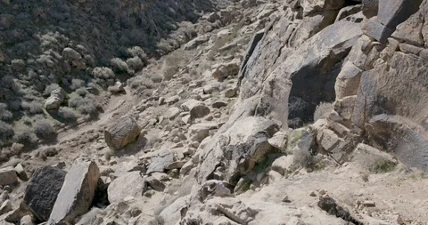 Elevated view of hikers climbing down the rocky mountain on a sunny day Stock Footage 145281687