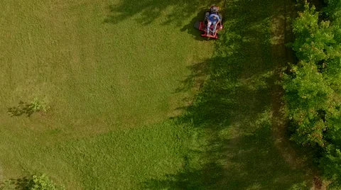 Elevated view of man cutting grass on a riding lawn mower Stock Footage 63213955
