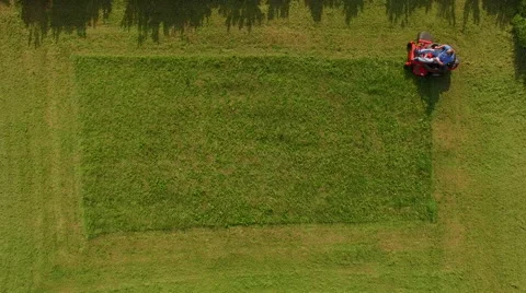Elevated view of man cutting grass on a riding lawn mower Vidéo 63218217