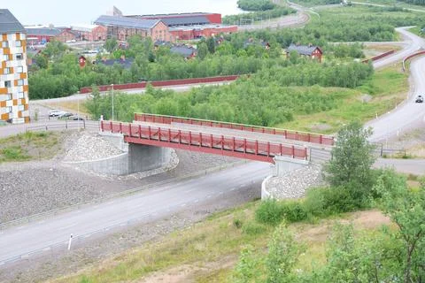 Elevated view of a modern bridge with a red wooden railing spanning across a  Stock Photos