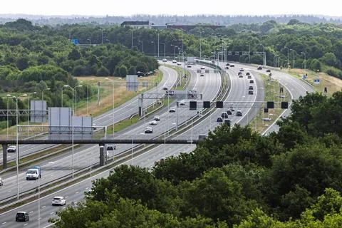 An elevated view of a multi-lane Dutch highway bustling with cars, winding th Stock Photos