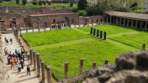 Elevated view of Pompeii’s green peristyle courtyard with visitors, long Vidéo 336216265