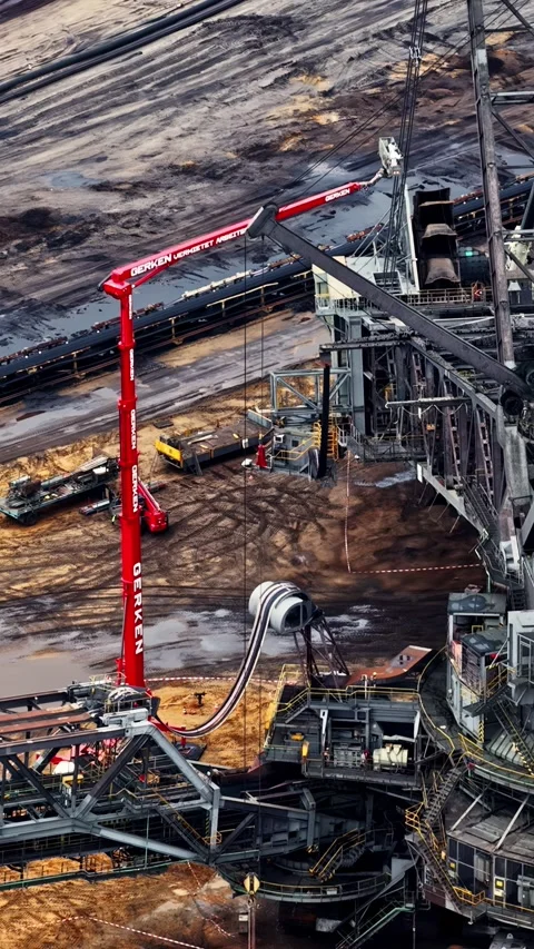 Elevated view of a red mobile crane and conveyor machinery at Garzweiler II Stock Footage 344523125