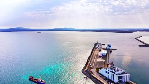 Elevated view of sea port pier with cargo ship and mountain backdrop, Bulgaria Stock Footage 337197675