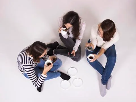 Elevated view, shot from above, three girls chatting. White background Stock Photos