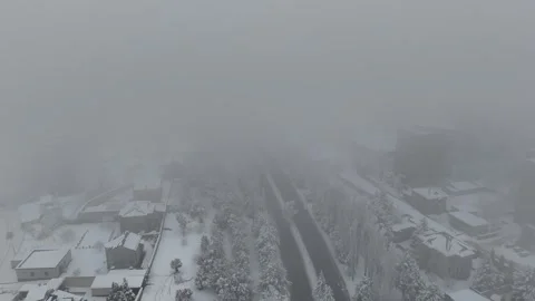 Elevated view of a snow-covered urban road and frosty trees. Video stock 328913328