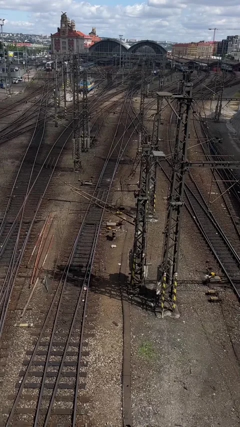 Elevated view of urban rail yard with converging tracks and catenary pylons Видео 341626460