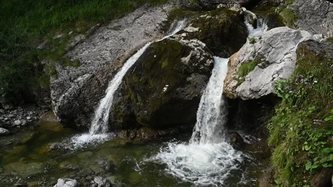 Elevated view of waterfalls splash into a pond after sunset in slowmotion Stock Footage 260822663