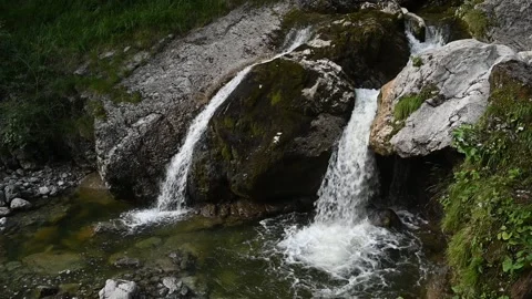 Elevated view of waterfalls splash into a pond after sunset in slow motion Stock Footage 260823470