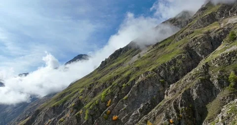 Elevation above the clouds, along a rocky ridge, with high mountain pastures Stock Footage 314007994