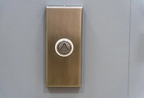 Elevator call button with up arrow on metal panel Stock Photos