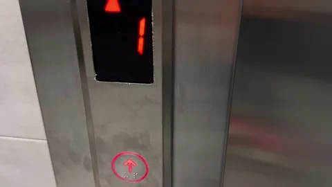 Elevator call button with illuminated up arrow and floor display in modern build 스톡 동영상 339490121