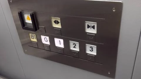 Elevator control panel with buttons for different floors and directions in .. Stock Photos