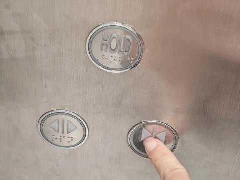 Elevator control panel with HOLD button, Braille and directional controls 스톡 사진
