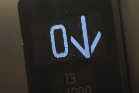 Elevator display shows zero and down arrow in a building Stock Photos