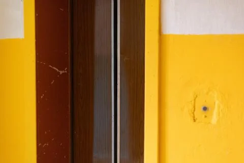 An elevator door in a deteriorating building with visible wear and peeling .. Stock Photos