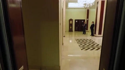 Elevator doors closing with security guards in the distance in a hotel in Stock Footage 80156724
