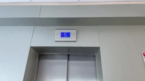 Elevator entrance with blue floor indicator displaying number five Stock Footage 342826778