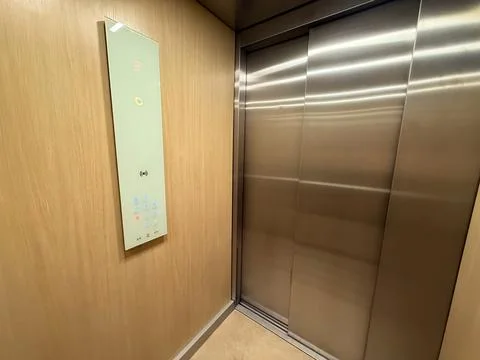 Elevator interior with digital control panel and closed metal doors inside .. Stock Photos