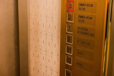 Elevator interior with golden buttons for third floor Stock Photos