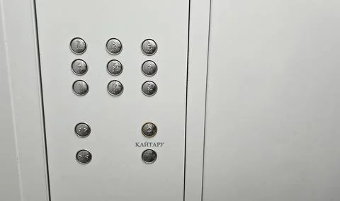Elevator pushbutton panel with Braille and inscriptions in Kazakh and Russian. Stock Photos