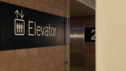 Elevator Sign Partially Hidden by Foreground Wall Stock Footage 346197796