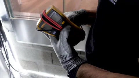 Elevator technician taking out voltmeter to test current lines on panel, Video stock 169281914