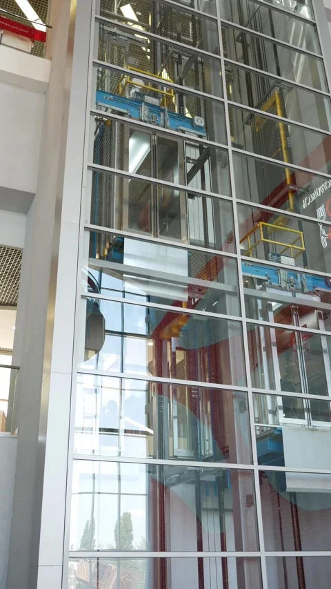 The elevators moves along a transparent shaft in a shopping center or business h Stock Footage 279145809