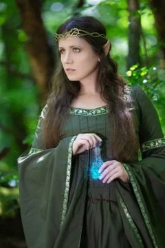 Elf with a bottle of magic potion in the forest Stock Photos