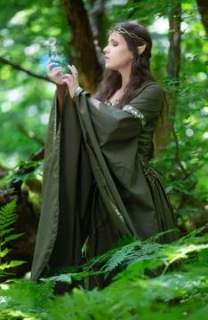 Elf with a bottle of magic potion in the forest Stock Photos