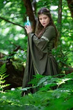 Elf with a bottle of magic potion in the forest Stock Photos