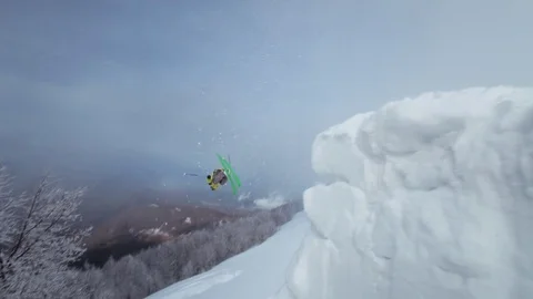 Elite freestyle skier jumping off of a trailside jump into powder snow Stock Footage 113222096