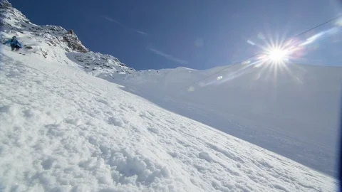 Elite skier cruising down a remote mountain with lens flare Stock Footage 113244698