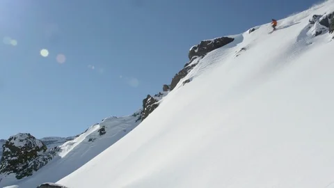 Elite skier cruising down a remote mountain with lens flare Stock Footage 113244728