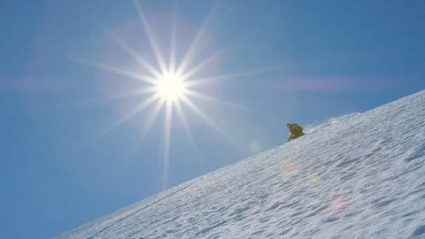 Elite skier cruising down a remote mountain on a sunny day Stock Footage 113257563