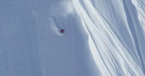 Elite skier cruising down the side of a powder covered mountain Stock Footage 111996205