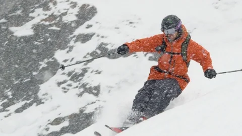 Elite skier cutting through fresh powder on a remote mountain while it snows Stock Footage 113241071
