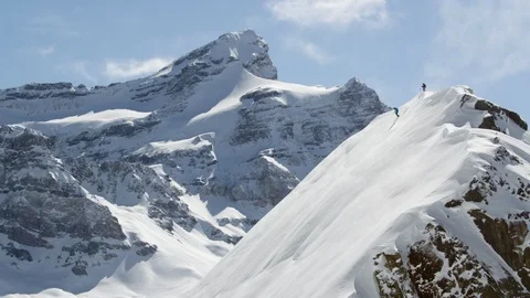 Elite skier descending from the summit of a remote mountain Stock Footage 113244954