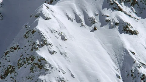 Elite skier jumping and skiing down the snow clad mountain Stock Footage 116786189