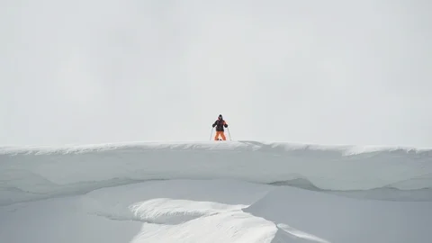 Elite skier jumping off cliffs and causing through a powder covered mountain Stock Footage 113220549