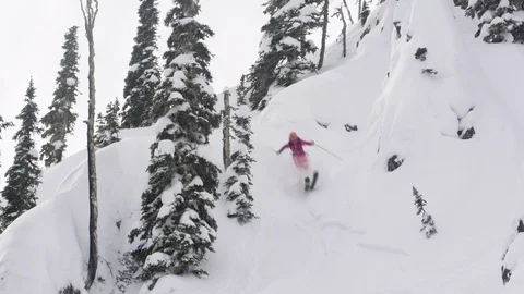 Elite skier jumping off huge ledge on a remote mountain Stock Footage 113233176