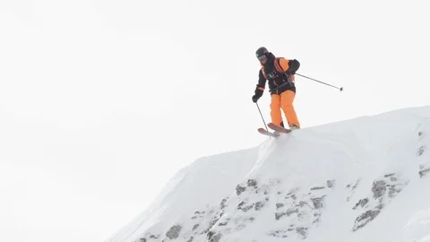 Elite skier jumping off rocky cliffs into fresh powder Stock Footage 113221128