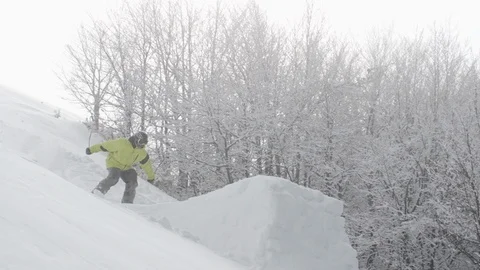 Elite skier performing a backflip 180 off a trailside jump into powder snow Stock Footage 113220293