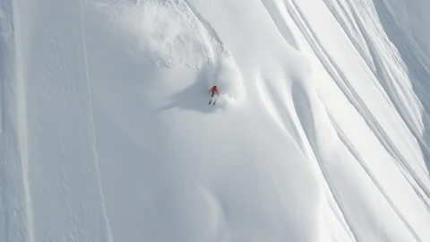 Elite skier racing an avalanche down a remote mountain Stock Footage 113257614