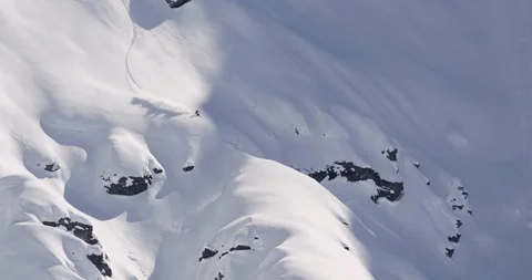 Elite skier racing down powder covered mountain from afar Stock Footage 111994355