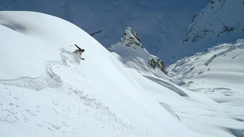 Elite Skier skiing down the mountain slope on a sunny day in slow motion Stock Footage 116789463