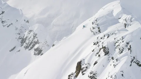 Elite skier speeding down a remote powder covered mountain slope Stock Footage 113250311